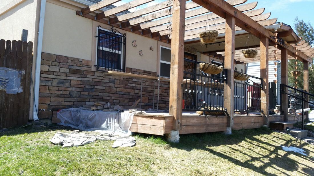 A house with a pergola and a deck in front of it.