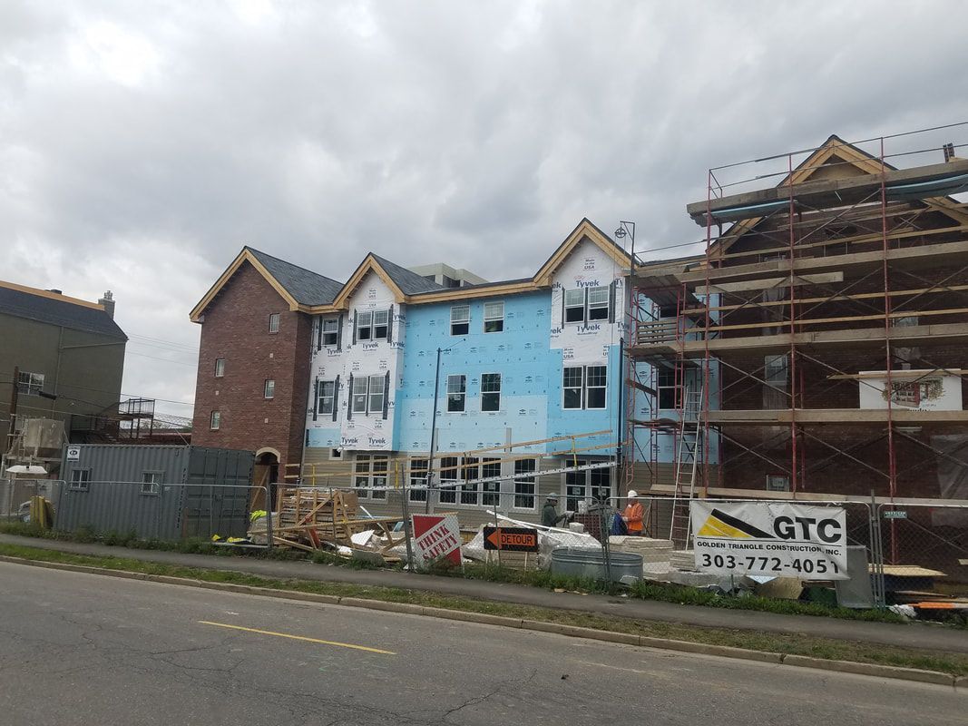 A row of buildings under construction next to a road.