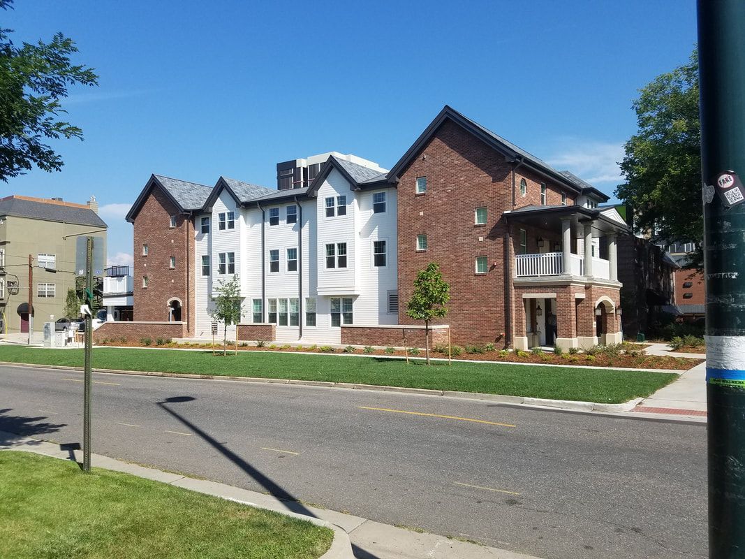 A large brick building is sitting on the corner of a street.