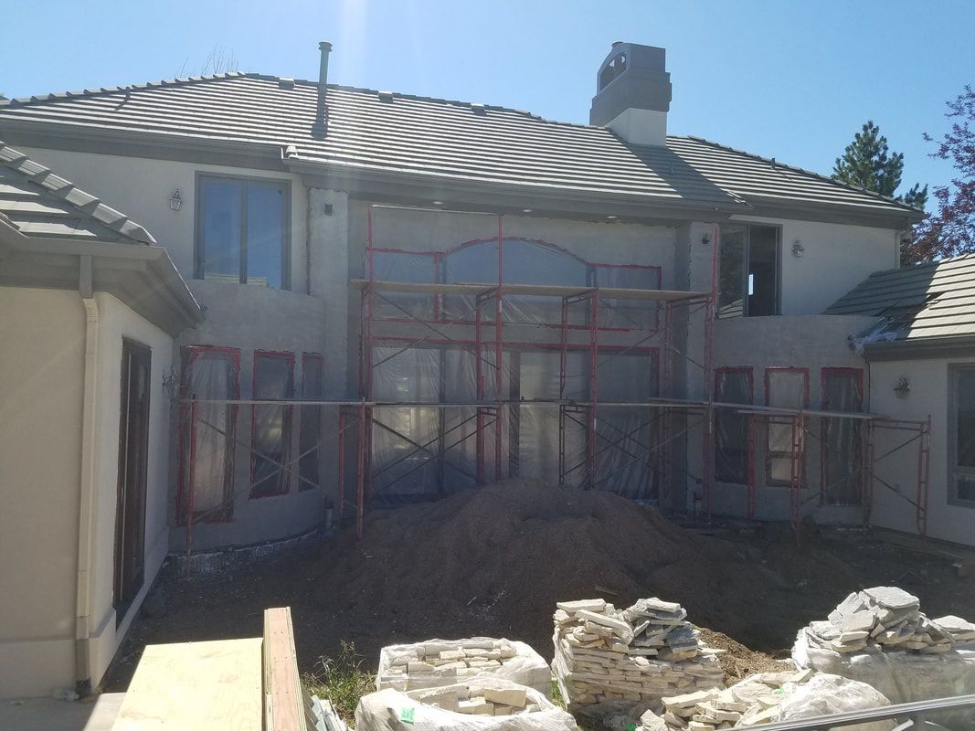 A large house with a striped roof is being built.