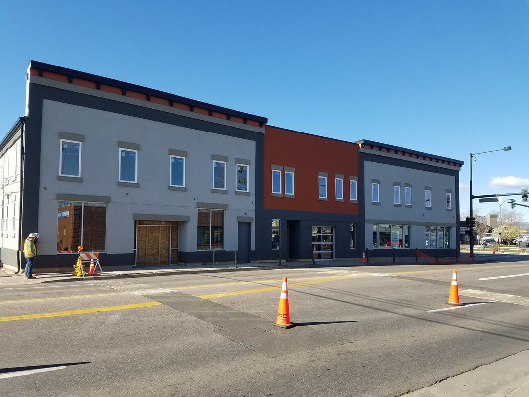 A large building is being built on the corner of a street.