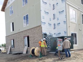 A group of construction workers are standing in front of a building under construction.