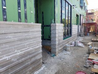 A building under construction with a brick wall and a lot of windows.