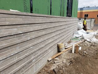 A large brick wall is being built on the side of a building.