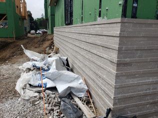 A stack of concrete blocks is sitting on the ground in front of a building under construction.