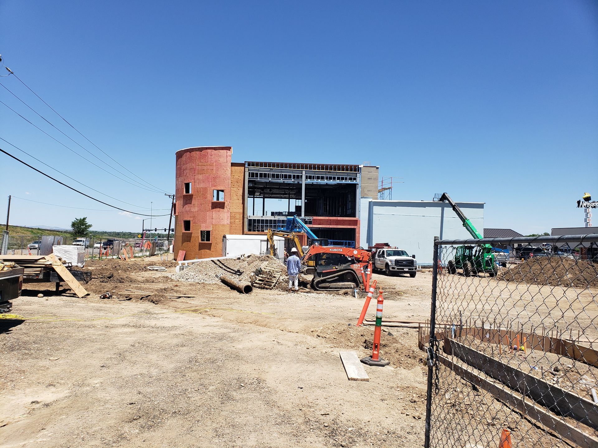 A large building is being built in a dirt field.
