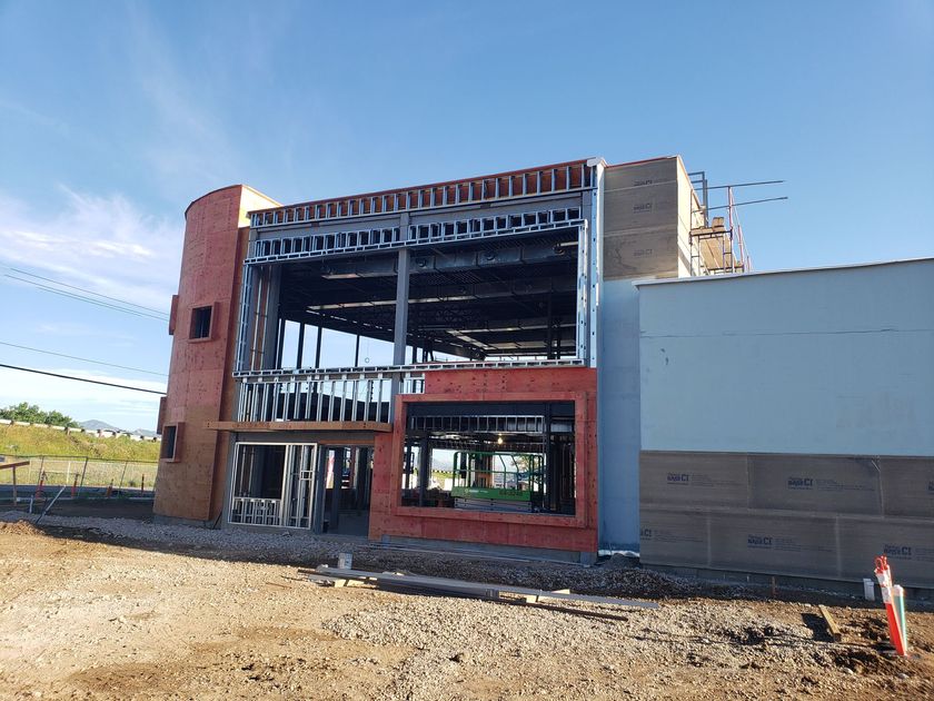 A large building under construction with a blue sky in the background.