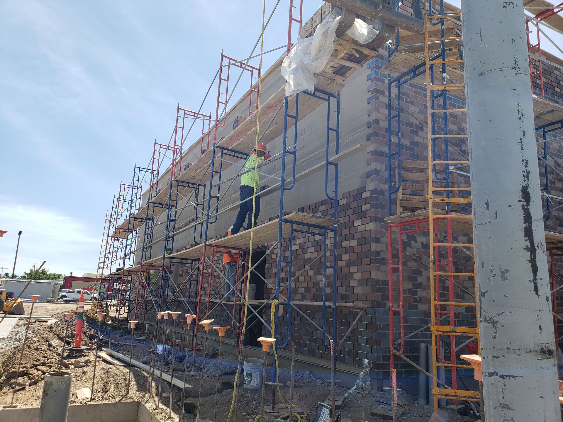 A man is standing on a scaffolding on the side of a building.