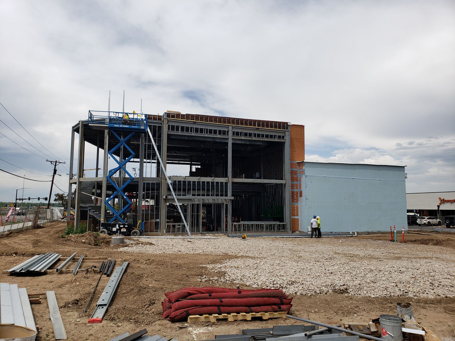 A large building is being built in a dirt field.