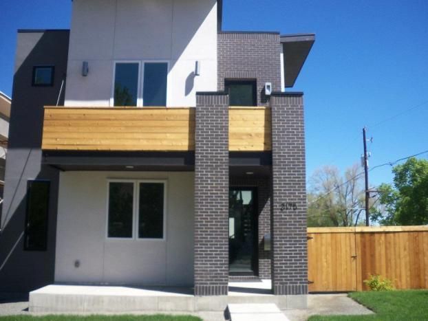 A brick house with a wooden balcony and a wooden fence