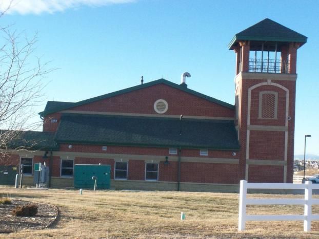 A large brick building with a white fence in front of it