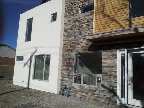 A white building with a stone wall and a lot of windows