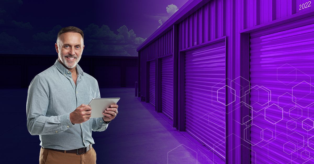man using tablet in front of storage units