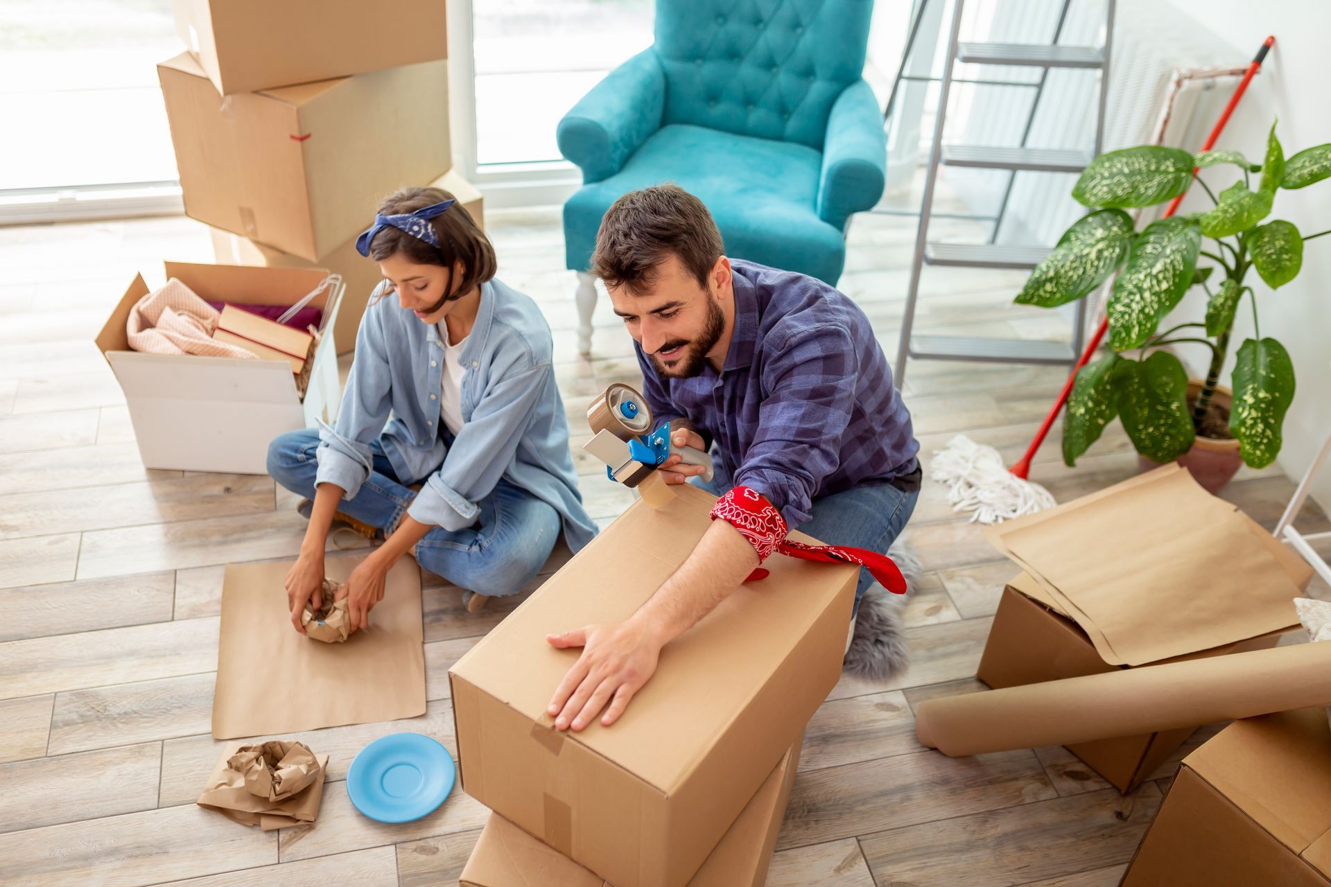 Man and woman packing boxes in their living room 