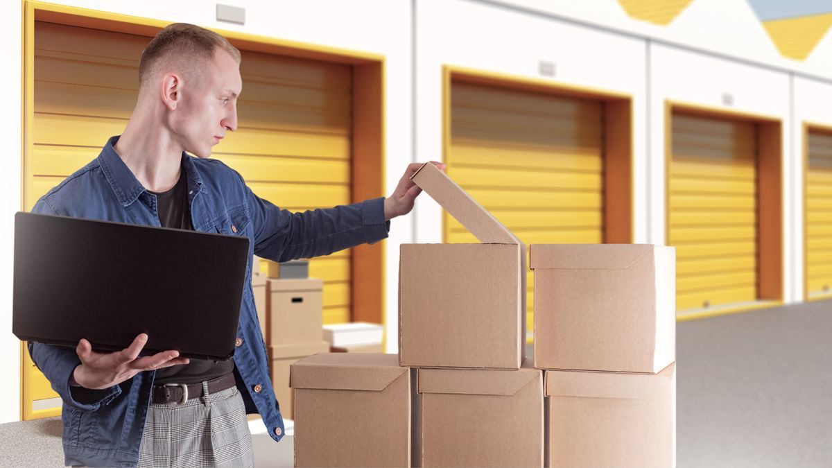 man using laptop at self storage facility