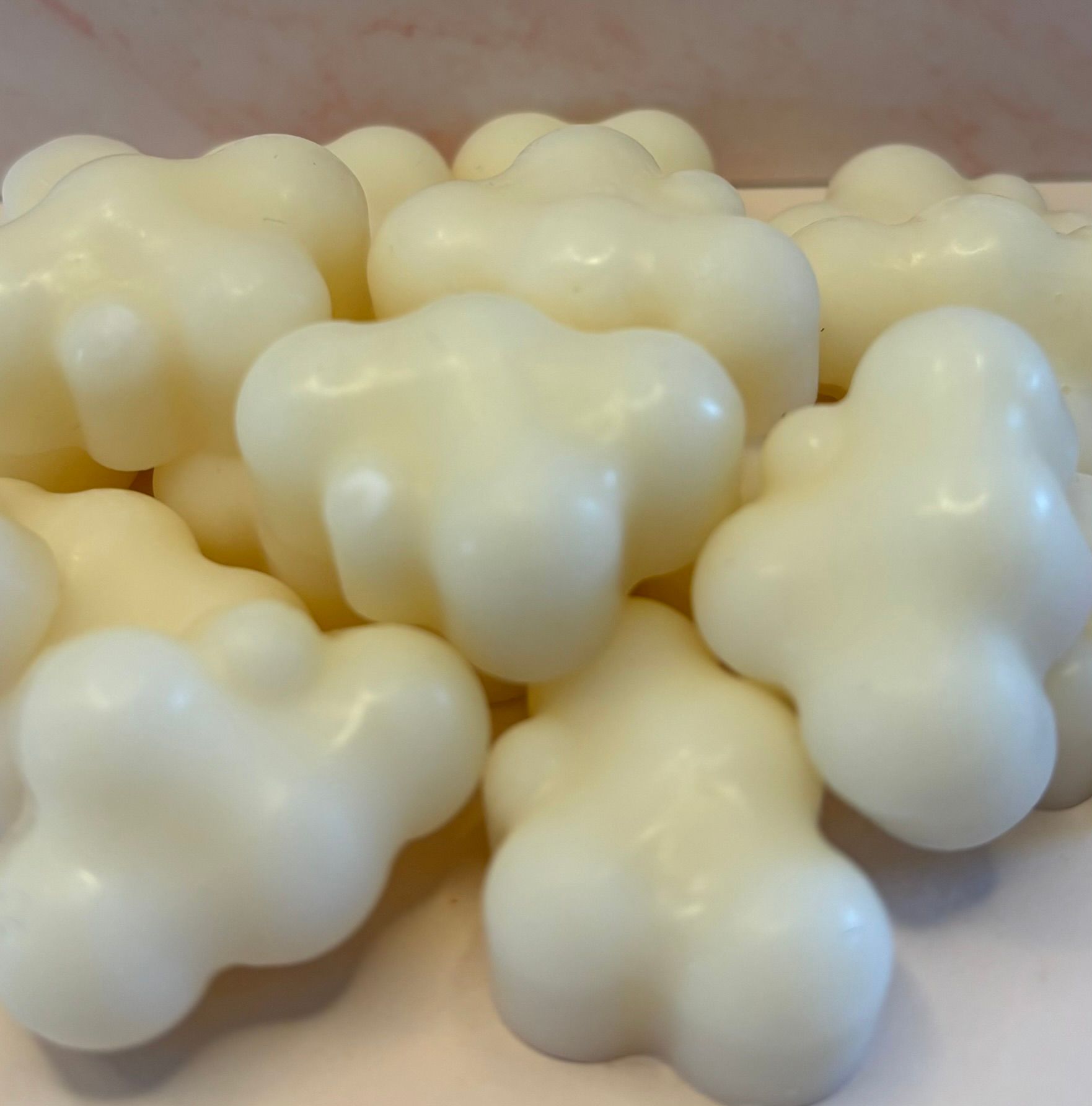 Een stapeltje kleine, gebroken witte, wolkvormige wasblokjes.