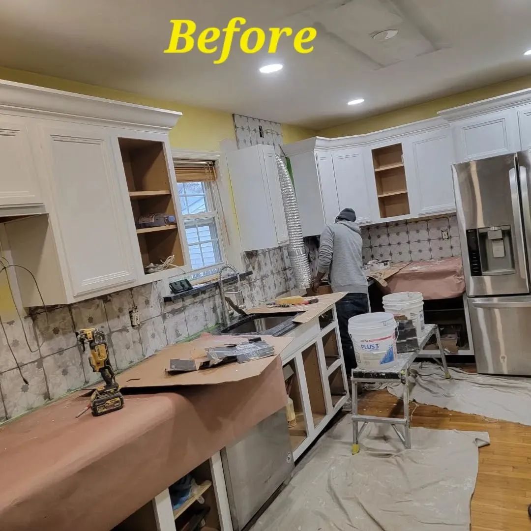 Kitchen renovation: cabinets, countertops, and appliances. Person working inside.