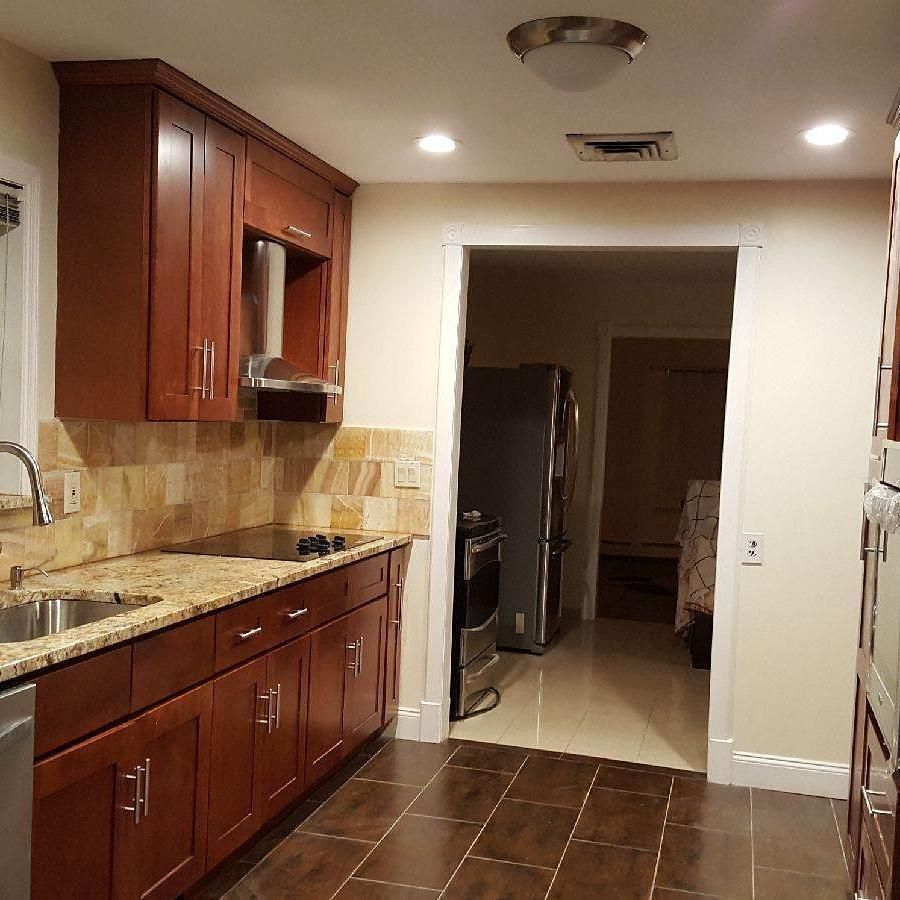 Kitchen with brown cabinets, granite countertops, and a doorway leading to another room.