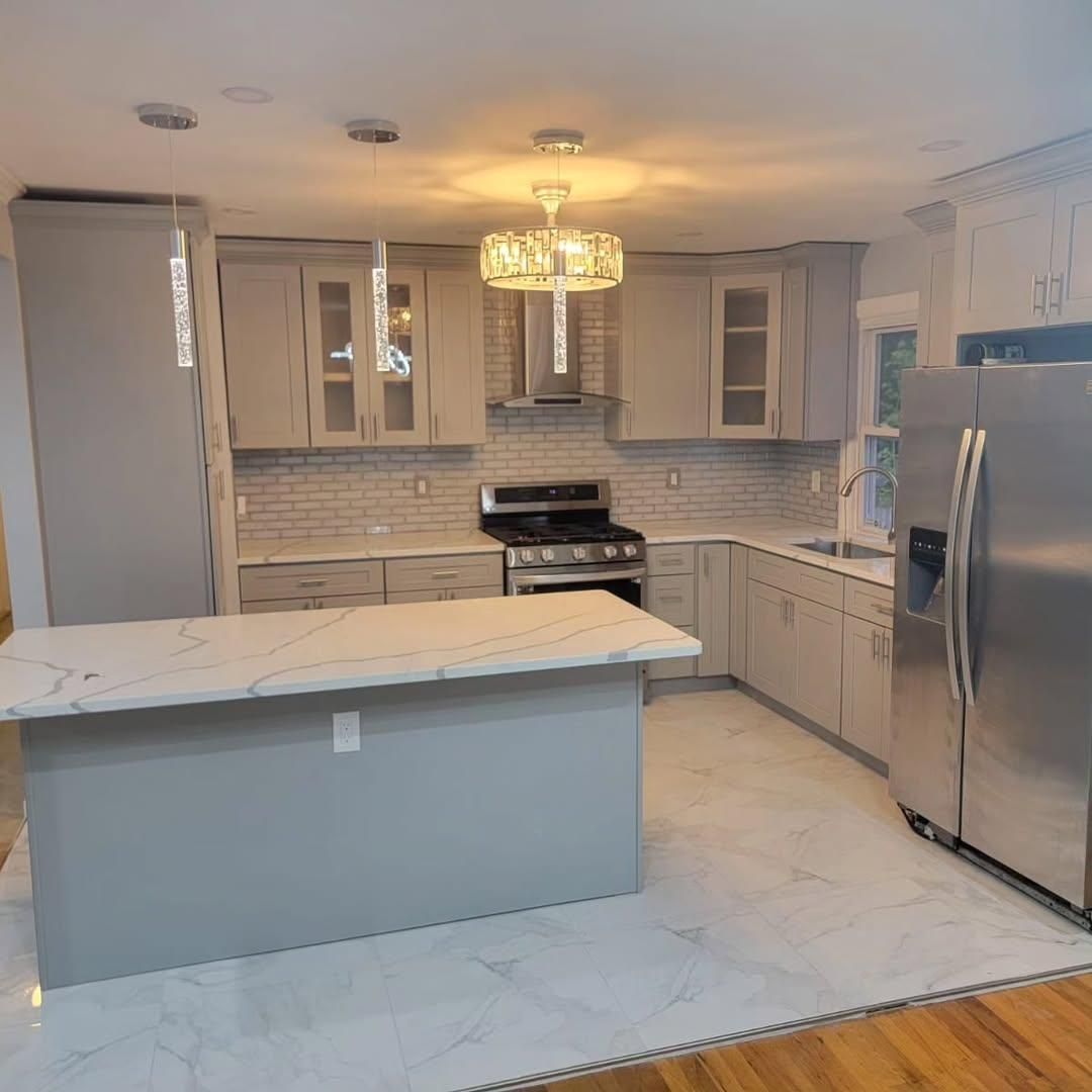 Newly renovated modern kitchen with gray cabinets, white countertops, and stainless steel appliances.
