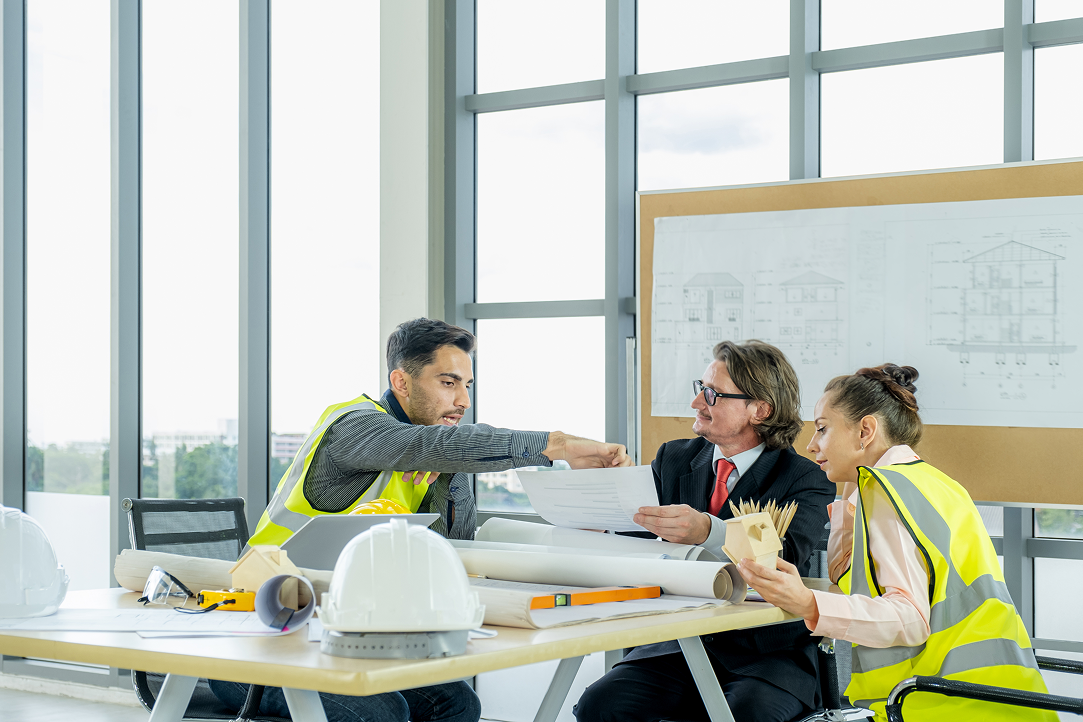A group of construction workers are having a meeting in an office.