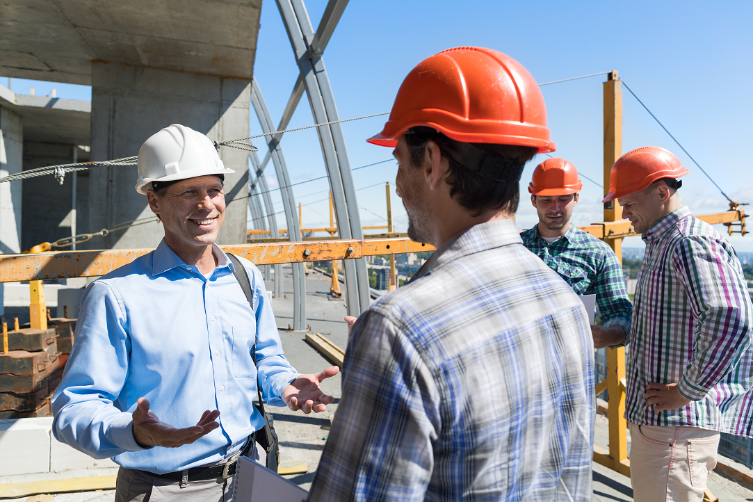 A group of construction workers are talking to each other on a construction site.