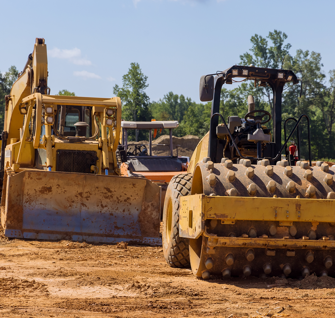 A bulldozer and a compactor are on a construction site