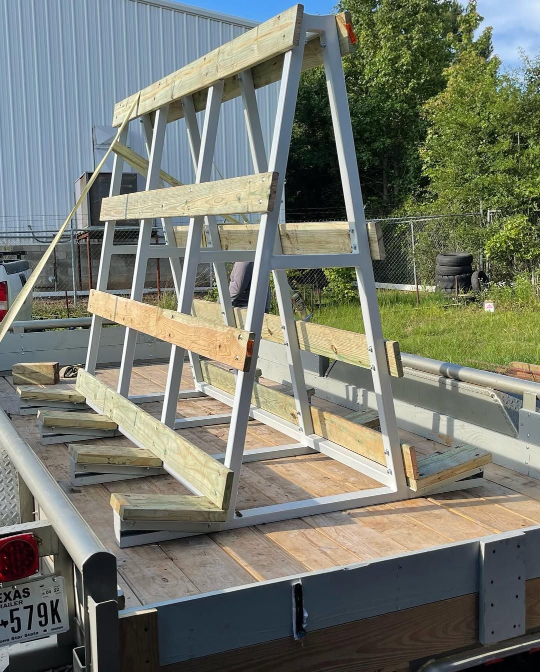 A-frame rack for hauling glass sheets, mounted on a flatbed trailer.
