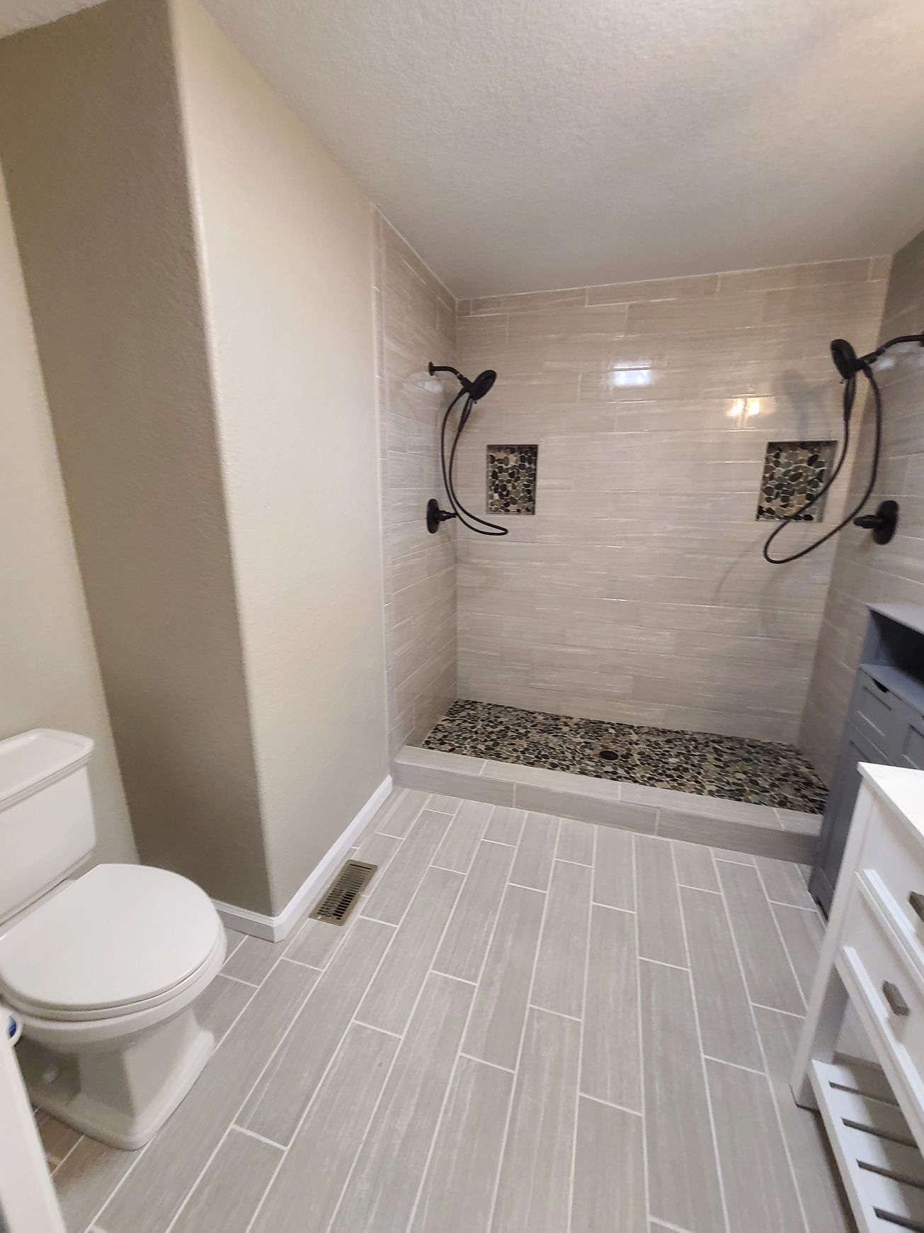 A bathroom with a toilet and a walk in shower.