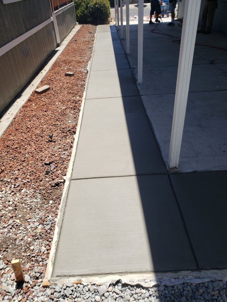 A concrete walkway is being built next to a house
