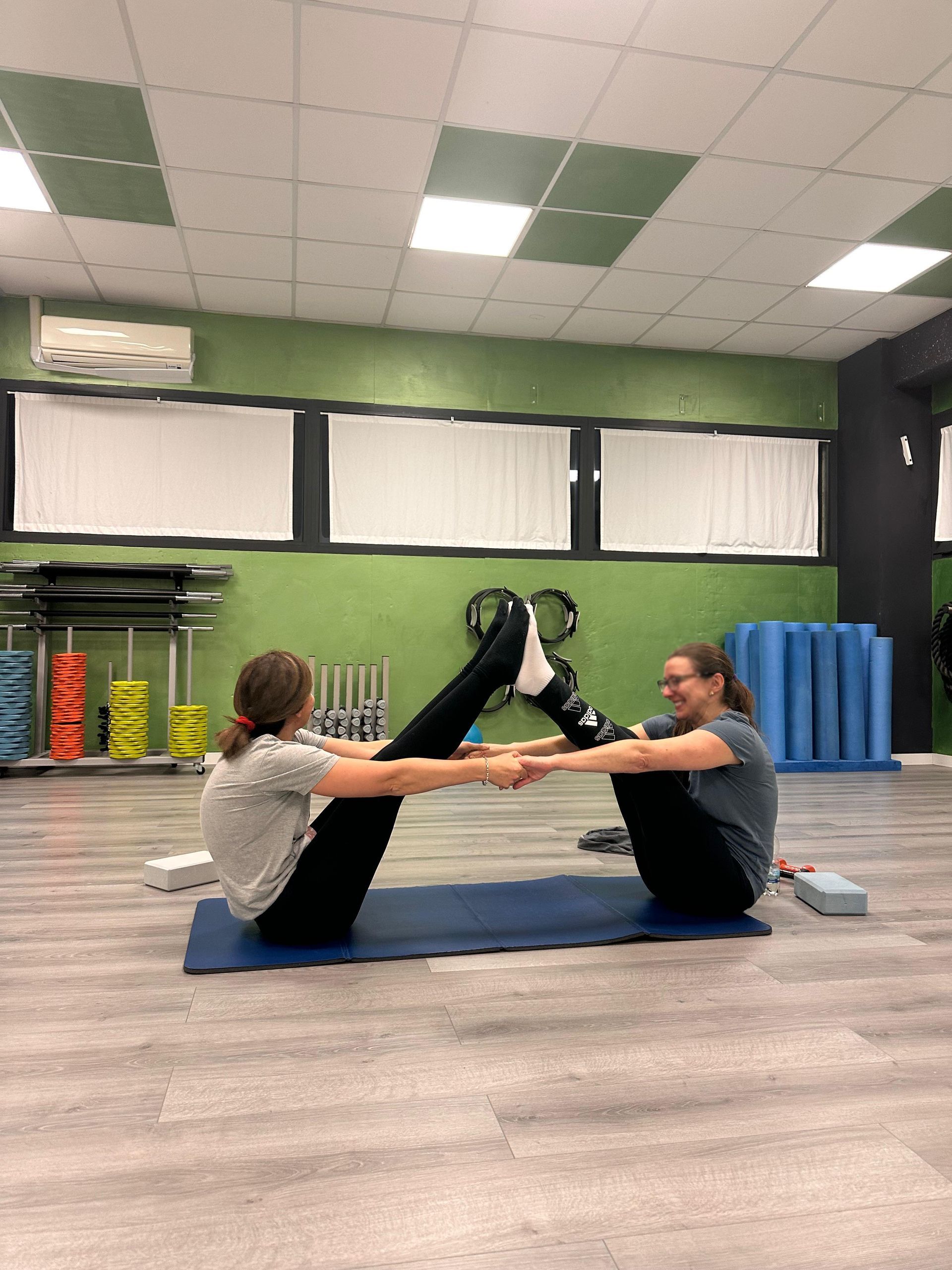 Un gruppo di persone sta facendo esercizi di pilates in palestra.