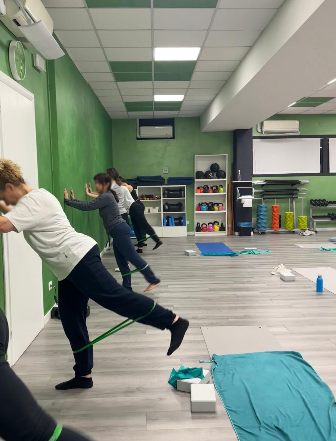 Un gruppo di persone sta facendo esercizi di pilates in palestra.