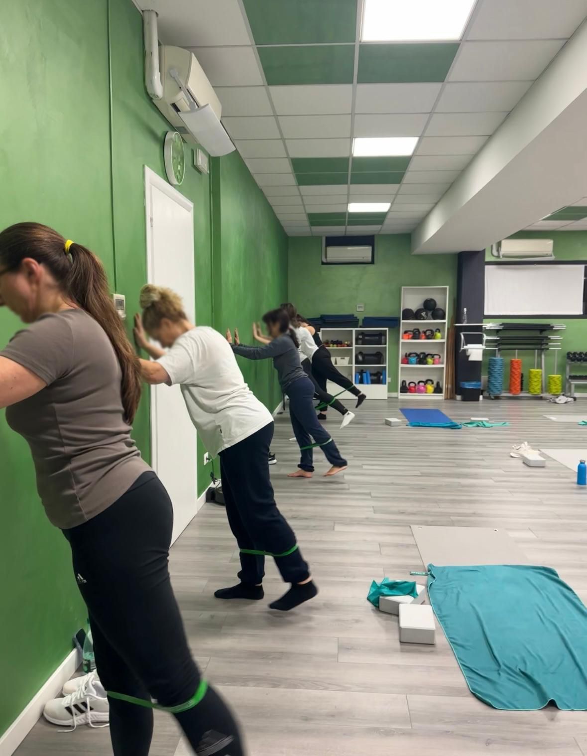 Un gruppo di persone sta facendo esercizi di pilates in palestra.