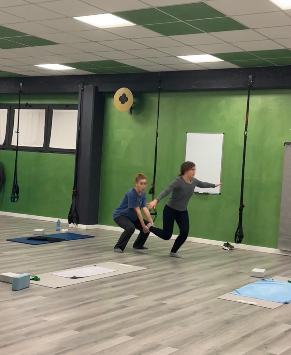 Un gruppo di persone sta facendo esercizi di pilates in palestra.