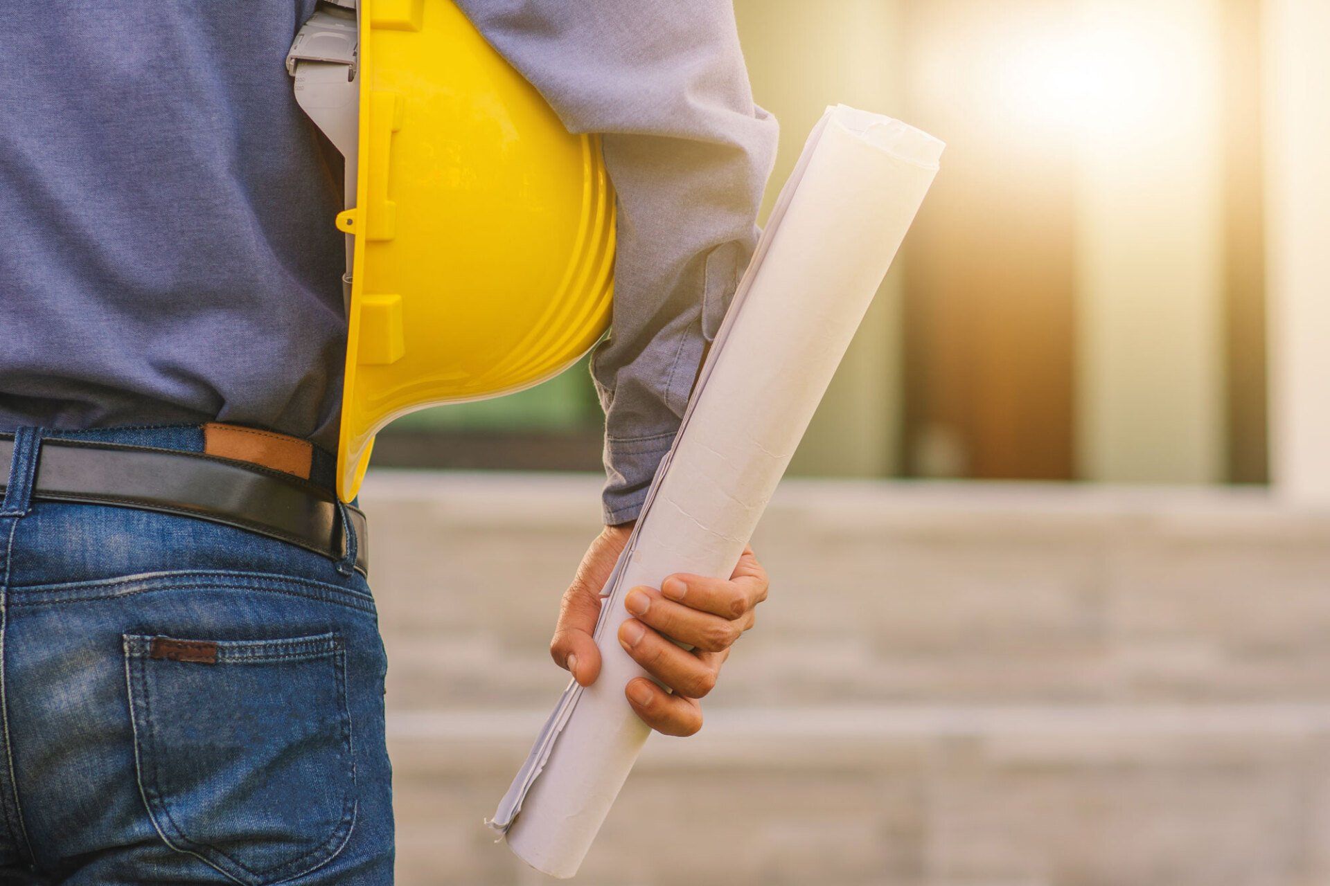 engineer holding hard hat on building construction background