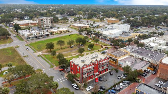 An aerial view of a city with a red building in the middle of it.