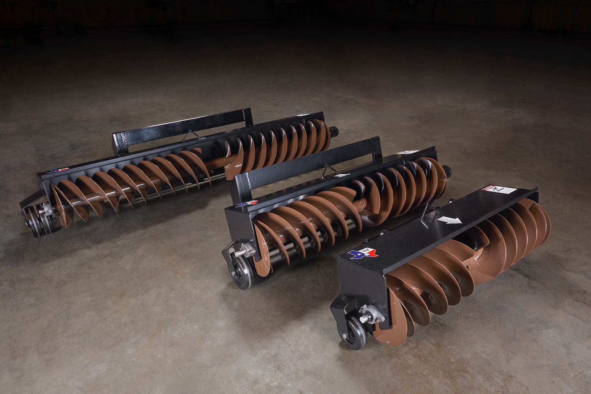 White skid steer loader on muddy ground near a grassy yard and wooden posts.