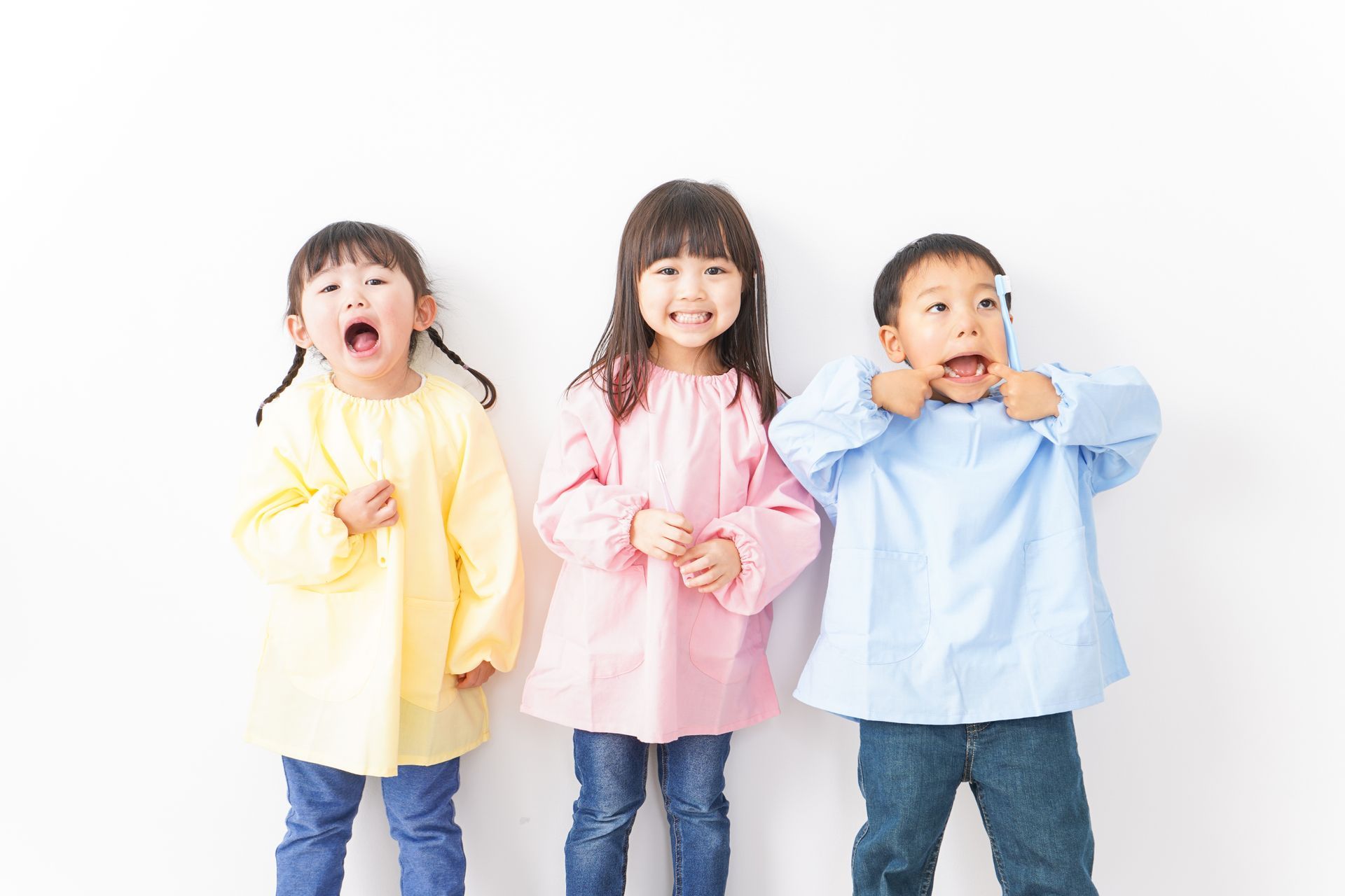 Trois enfants se tiennent côte à côte et font des grimaces.
