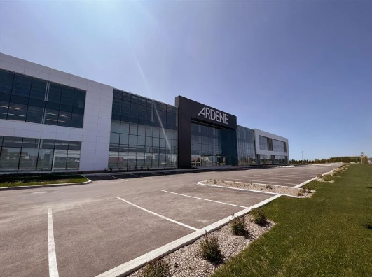 Une impression d'artiste d'un grand bâtiment avec un stationnement devant.