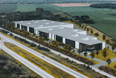 Une vue aérienne d'un grand bâtiment industriel à côté d'une autoroute.