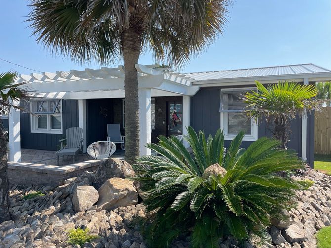 a house with a palm tree in front of it with shades from budget storm solutions