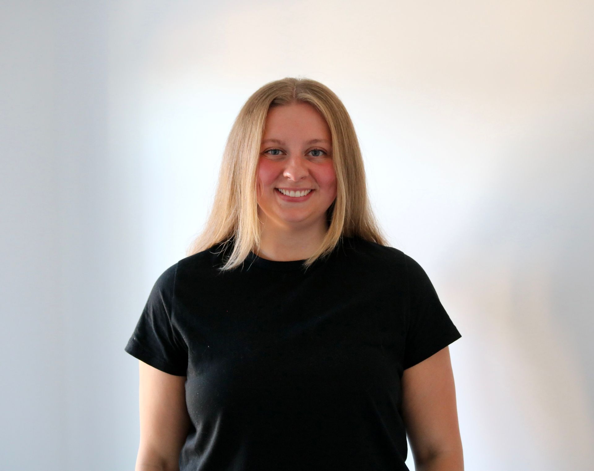 A woman in a black shirt is smiling for the camera.