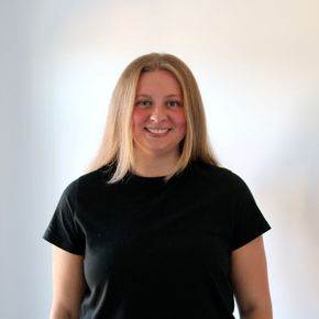 A woman wearing a black shirt is smiling for the camera