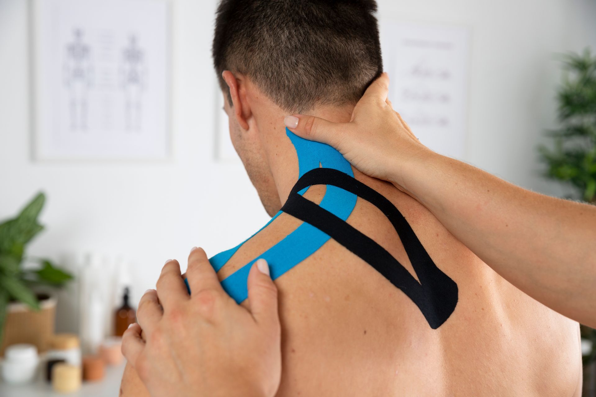 physiotherapist applying bandage on neck of patient treating sports injury