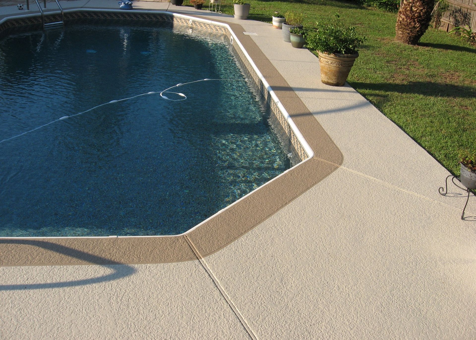A large swimming pool is surrounded by a concrete deck