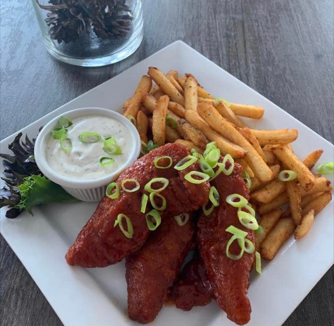 A white plate topped with chicken wings and french fries
