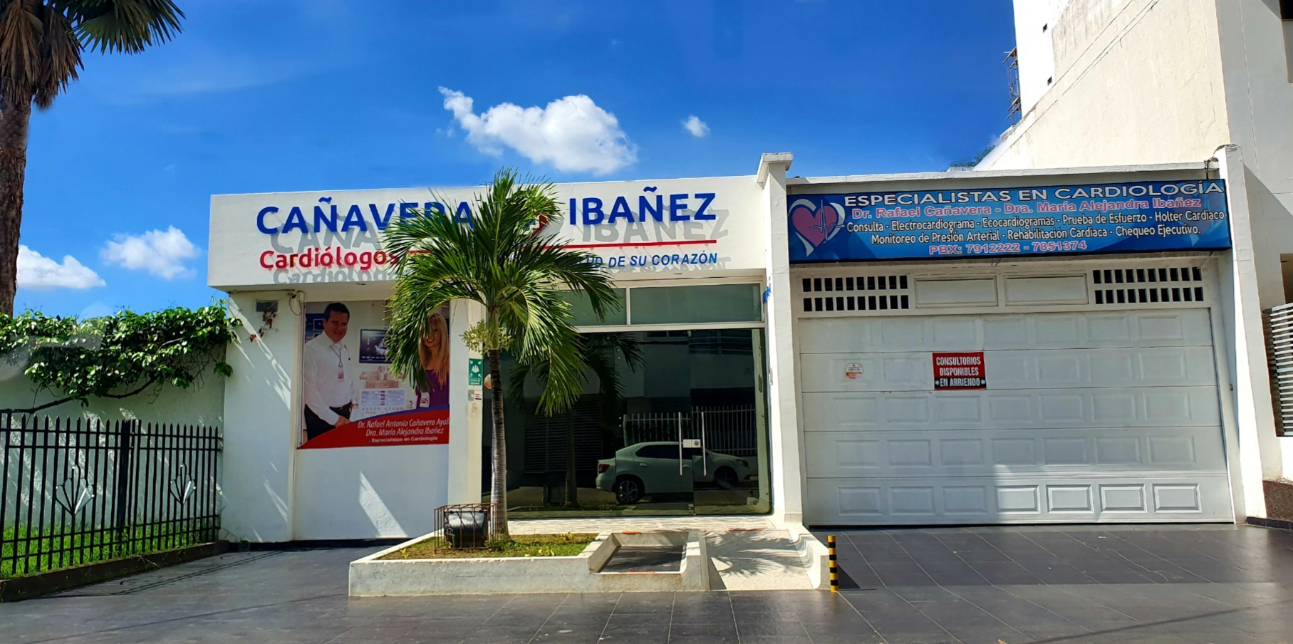 A white building with a garage door and a sign that says caravera ibanez
