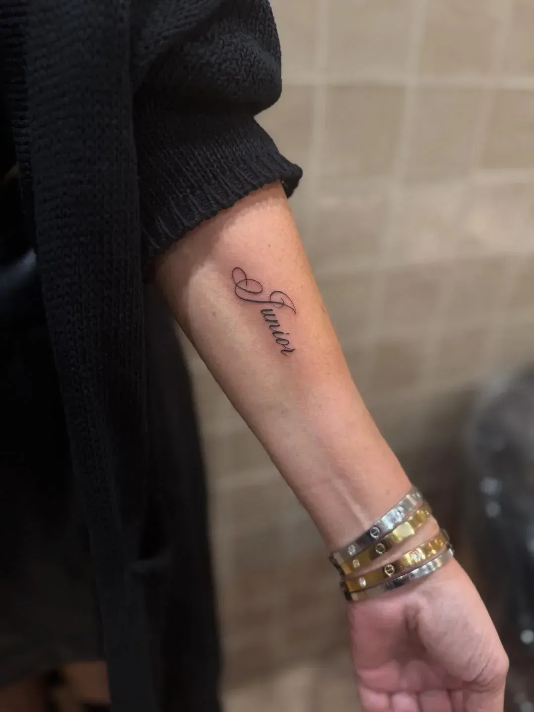 A close-up of an inner forearm featuring a cursive 