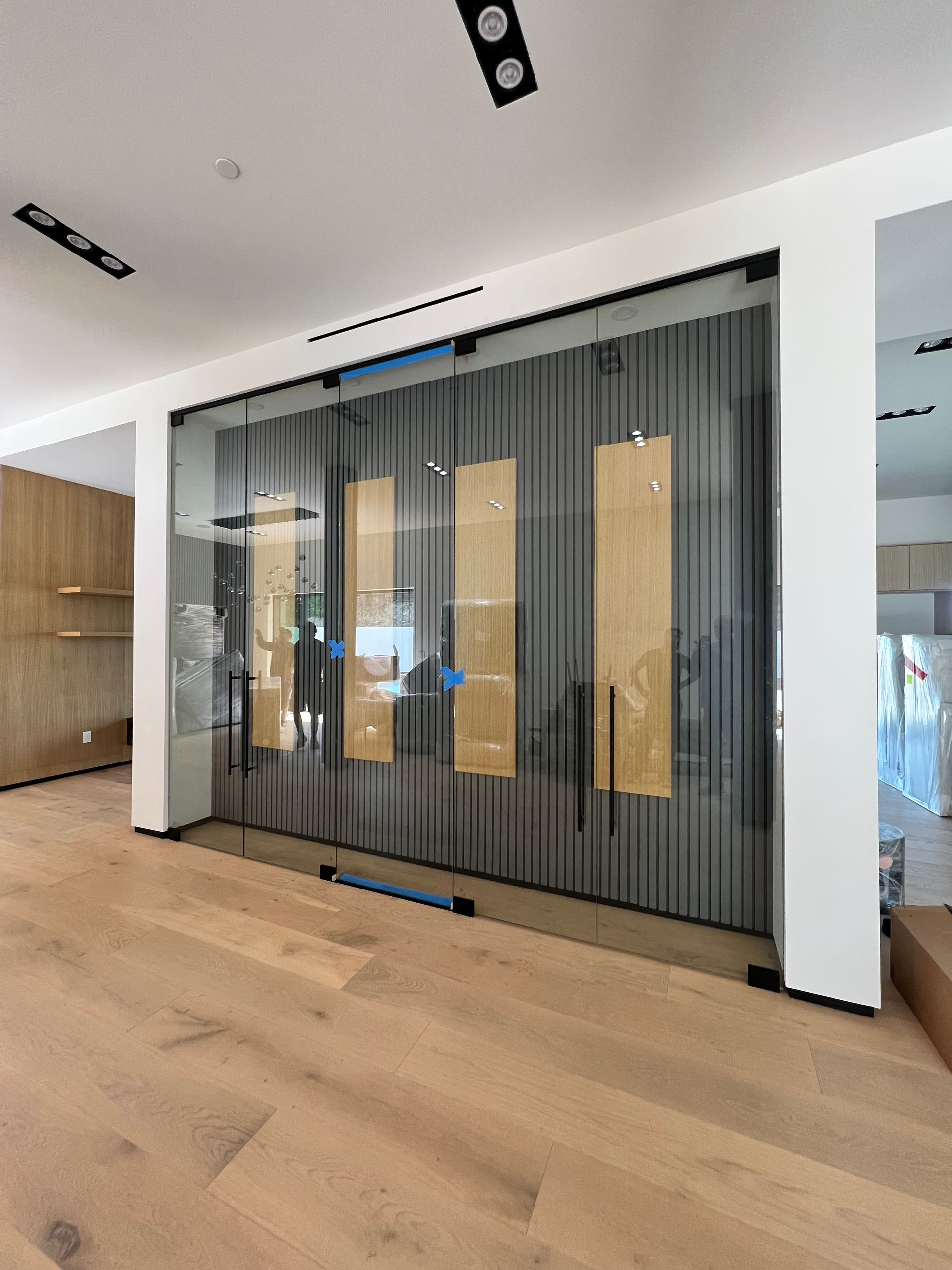 Modern interior with glass sliding doors, wood accents, and light wood flooring.