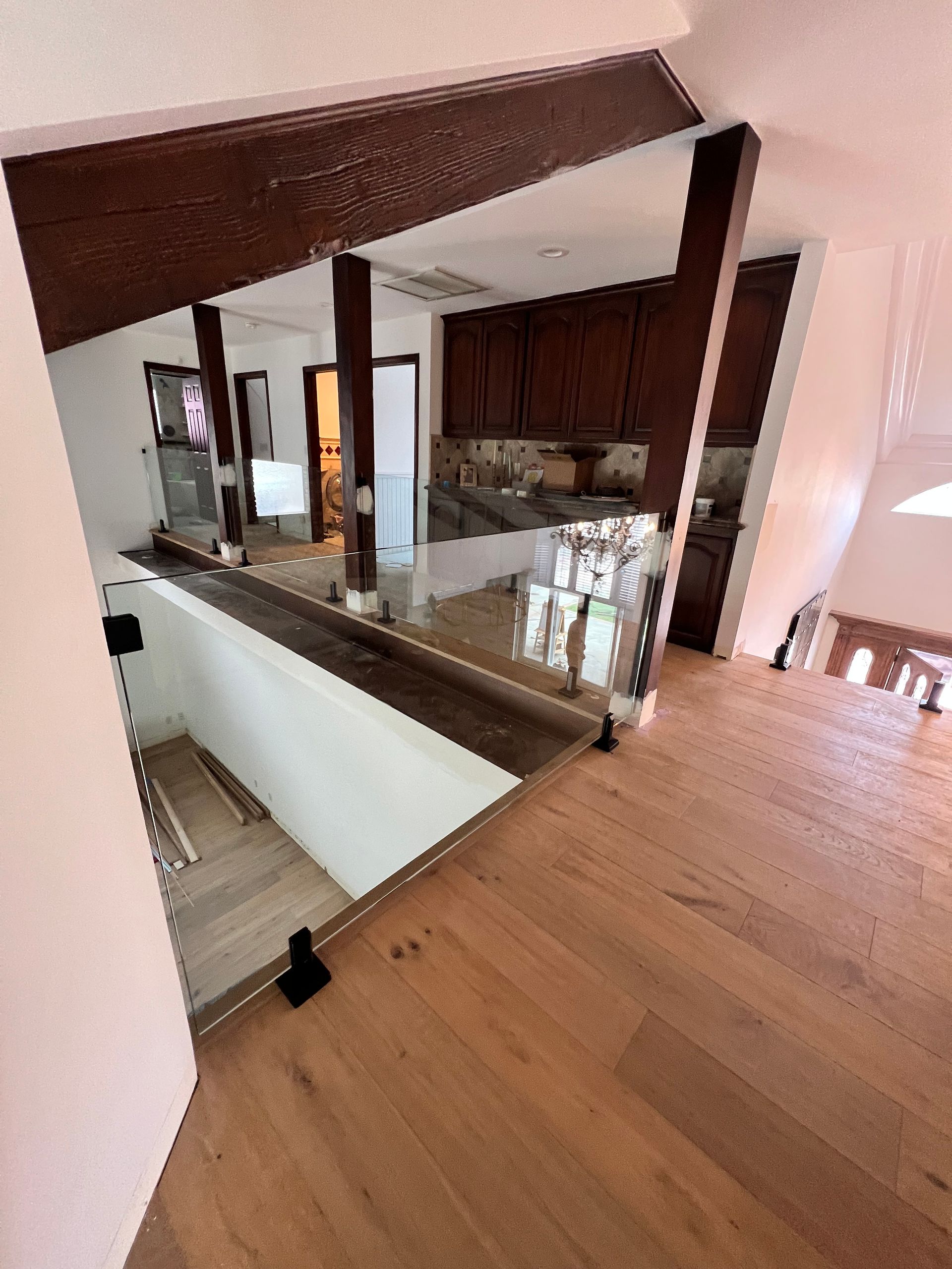 View from above of a kitchen and wooden staircase with a wooden beam ceiling.
