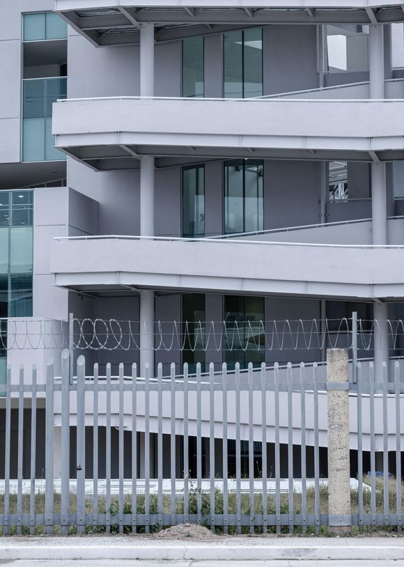 A building with balconies and a fence in front of it